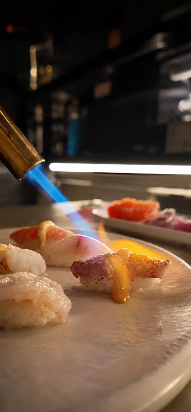 La fiamma sfiora i nigiri al bancone
