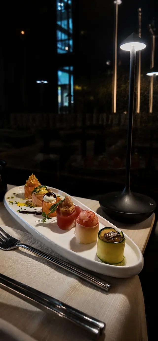 Roll cilindrici avvolti in zucchine e pesce con lampada nera